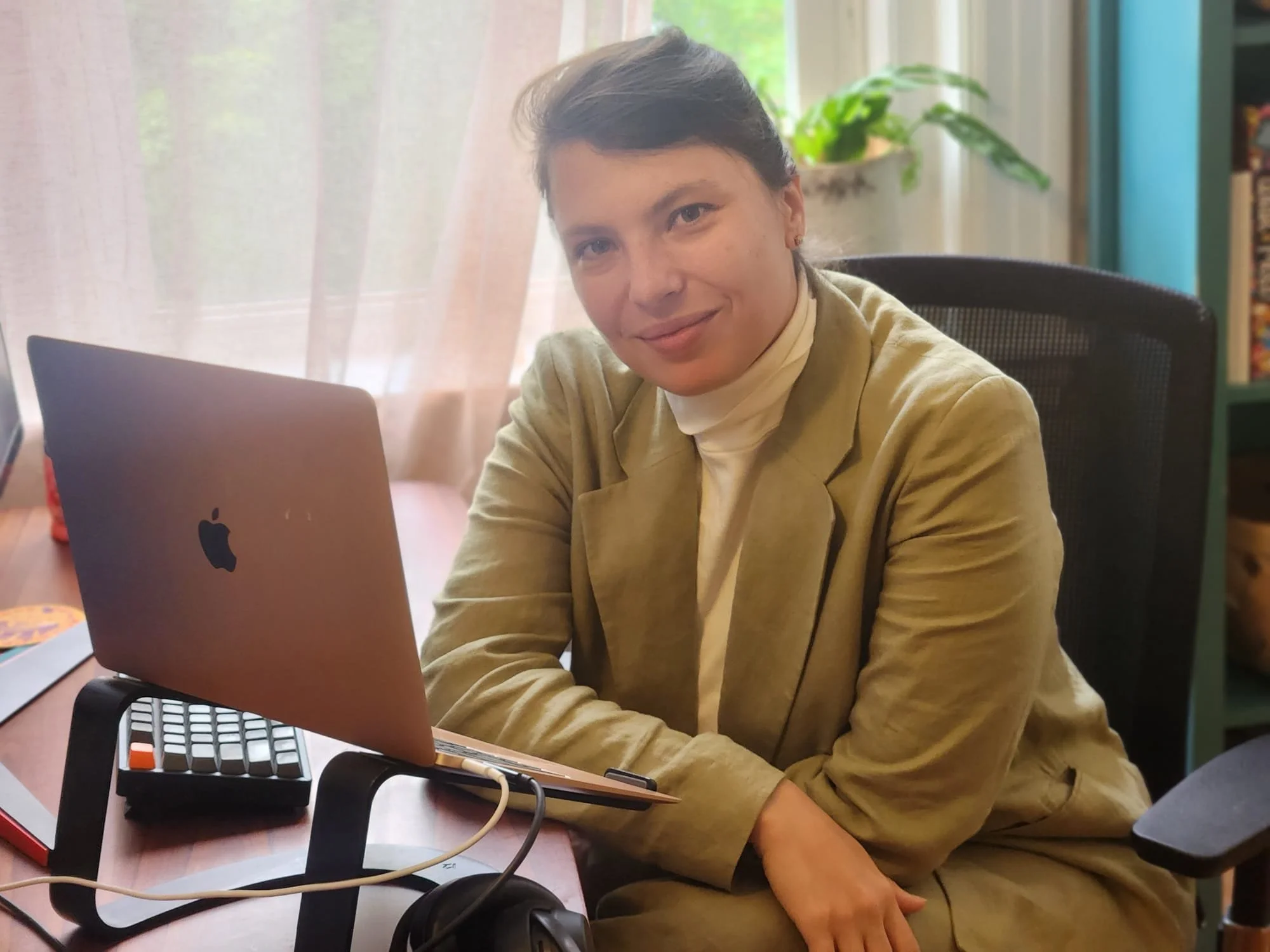 Masha Kartashev seated at her desk with bookshelves and plants in the background